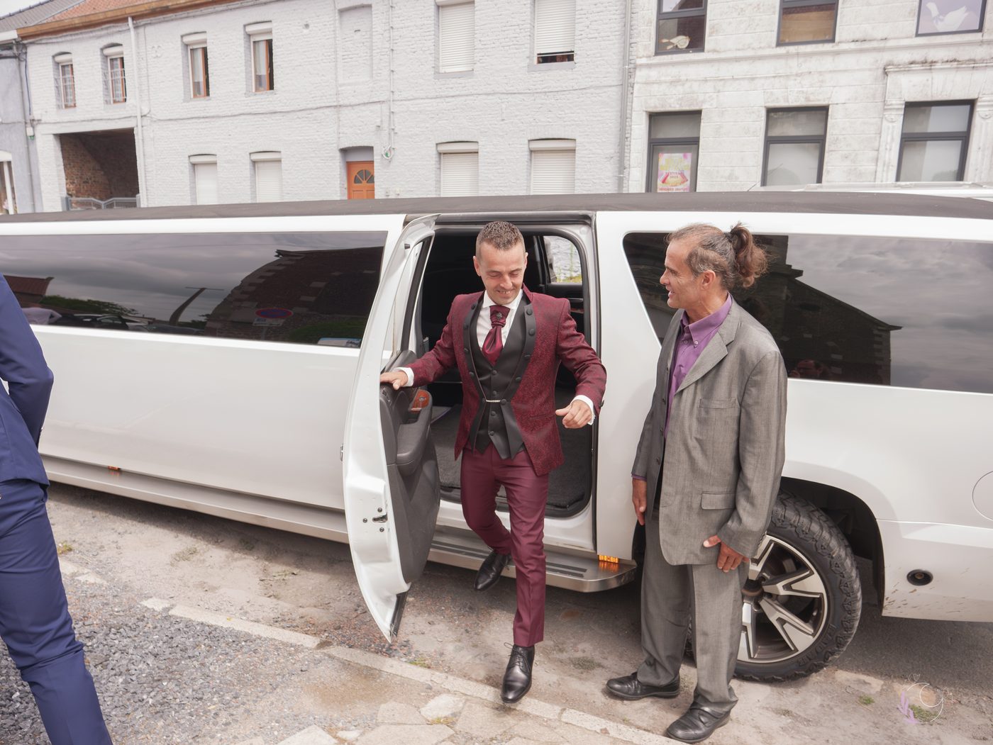 Marié descendant de la limousine, accueilli par ses proches