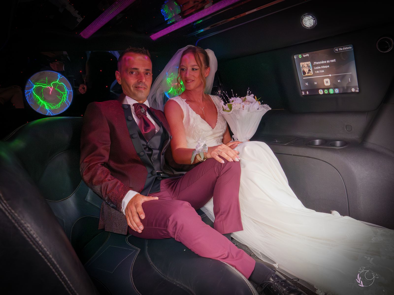 Les mariés complices à l'arrière de la limousine