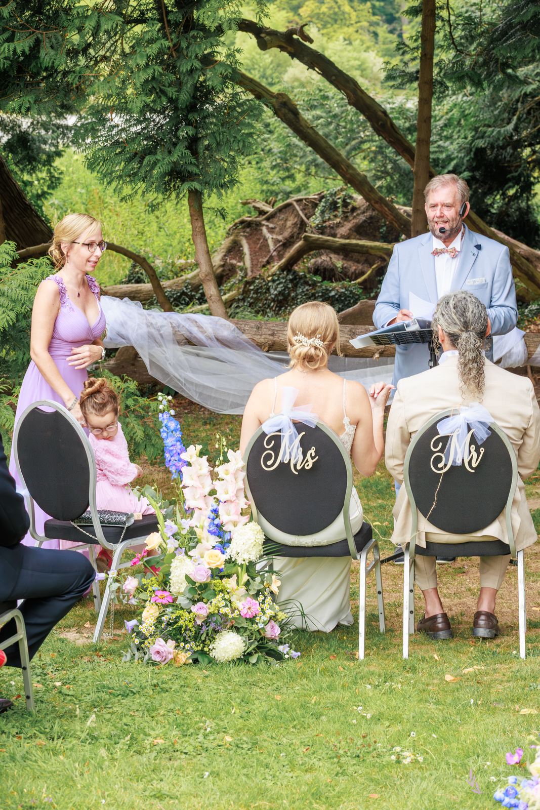 Chaises « Mr » et « Mrs » face à l'officiant, sous les arbres