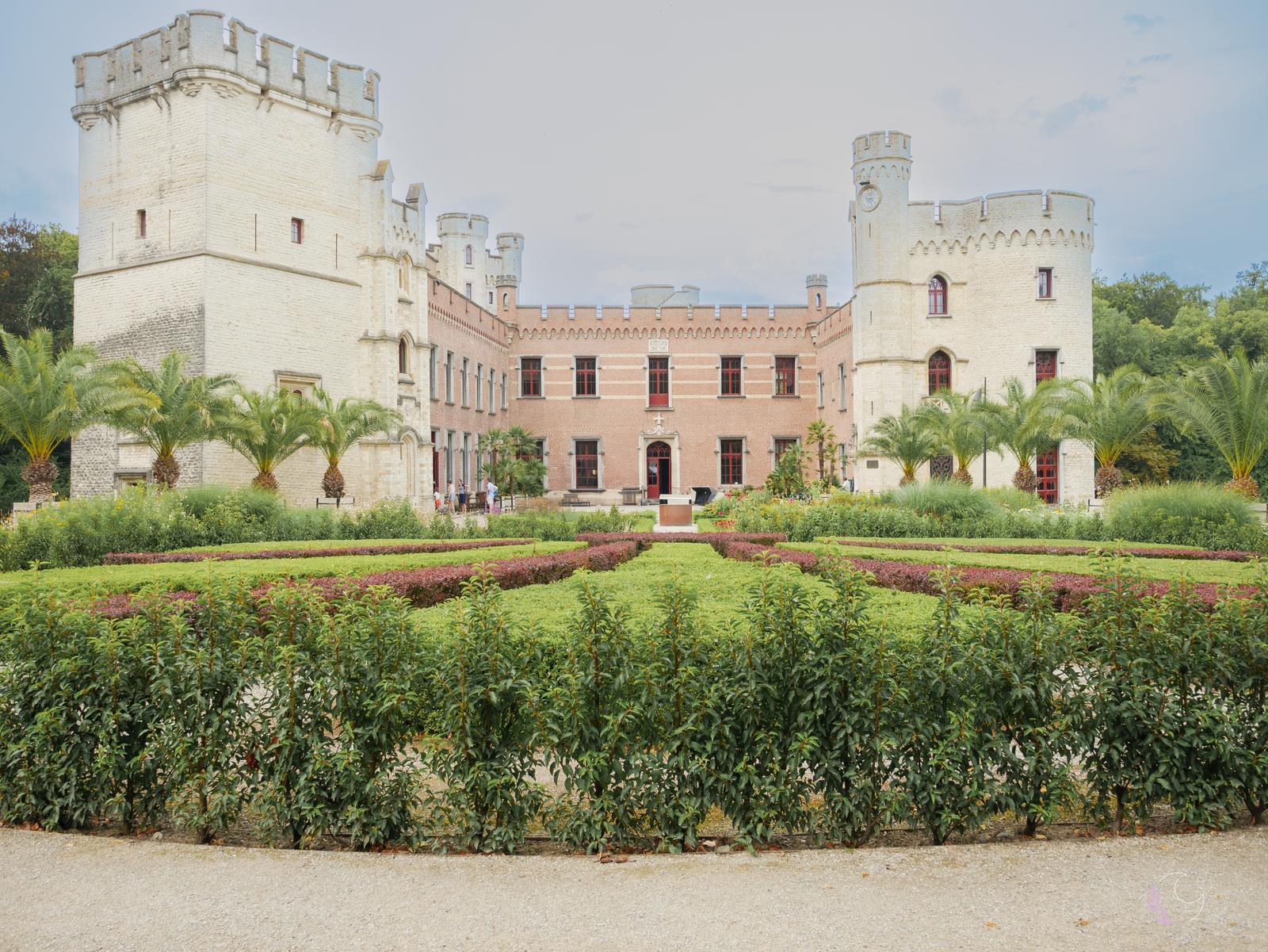 Façade du château avec ses deux tours et son jardin à la française
