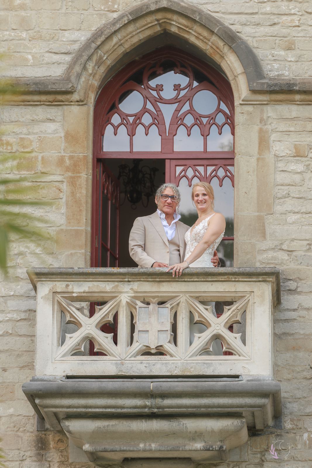 Les mariés au balcon du château, sous une fenêtre gothique