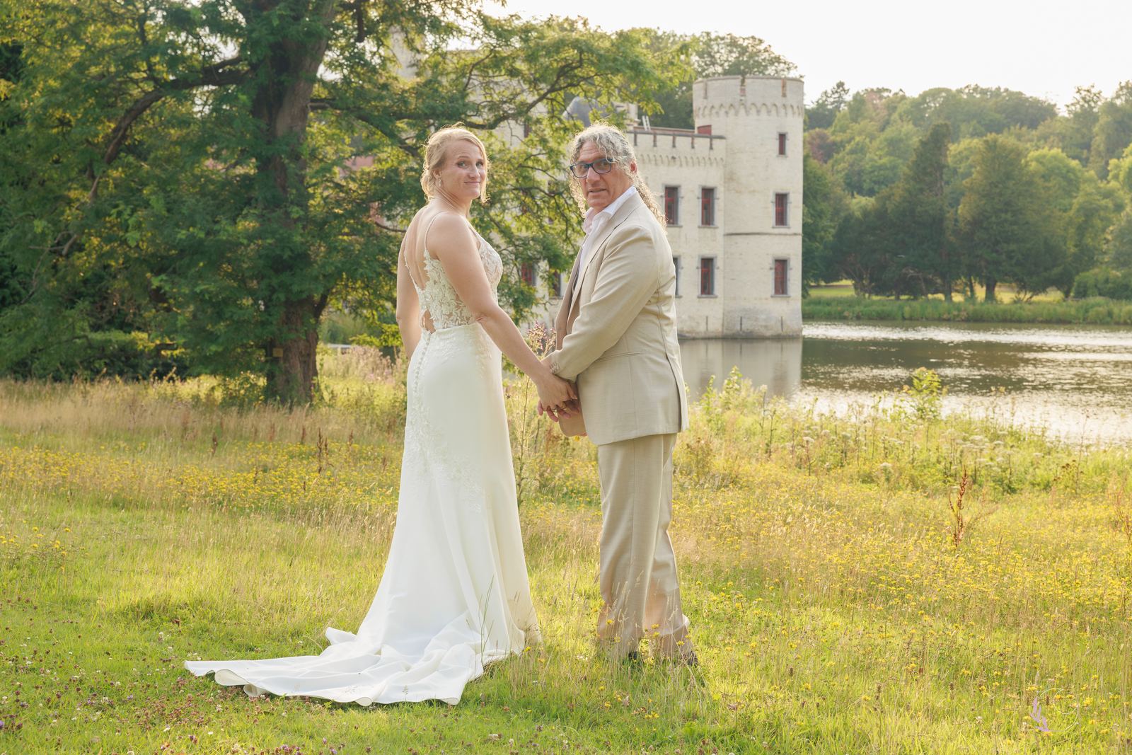 Les mariés dans la prairie, la tour du château se reflétant dans l'étang