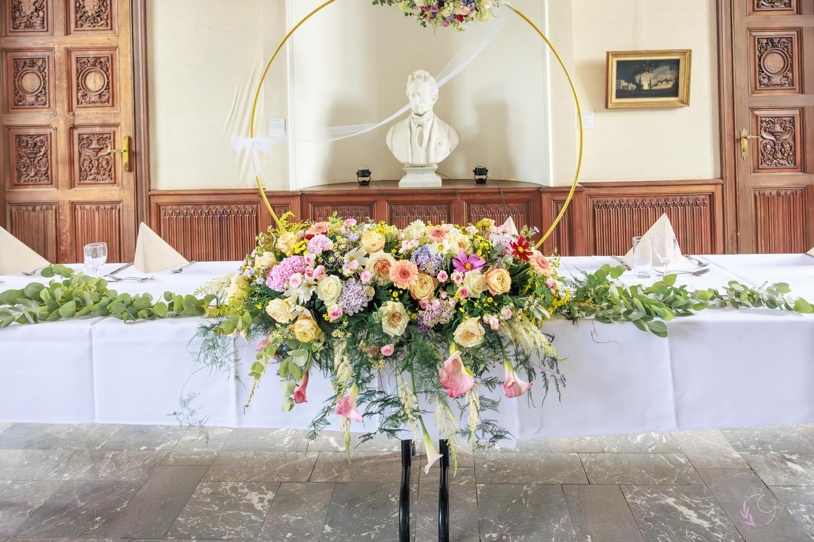 Arche florale dorée devant la table d'honneur
