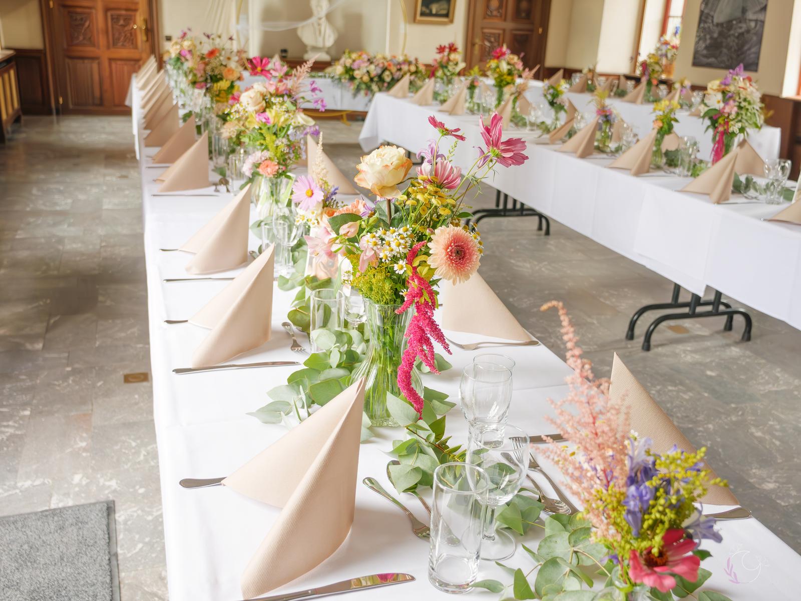 Table dressée dans la grande salle du château, bouquets champêtres