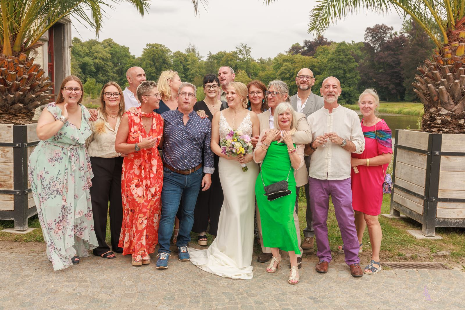 Grand groupe d'invités aux tenues colorées au bord de l'étang